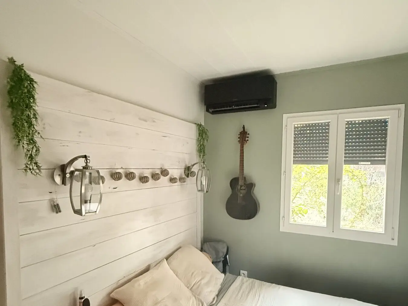 Climatisation Daikin Stylish noire installée dans une chambre aux tons verts à Saint-Sernin-du-Bois